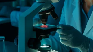 Cientista em laboratório examinando amostra de herpes sob microscópio, com ambiente iluminado em azul e tecnologia de ponta ao fundo.
